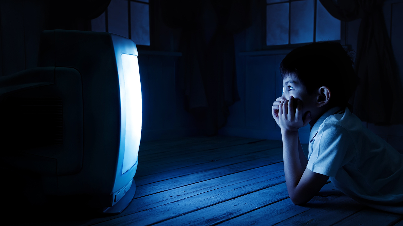 Young man watch tv in his own apartment. Cut view and close up of man  holding smartphone in hand. Laptop on his legs. Watch movie or program.  Entertain himself. - Stock Image -